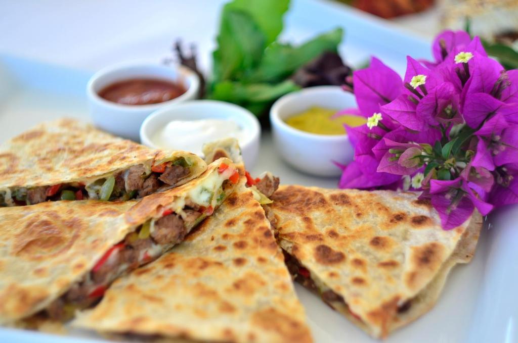 a plate of food with a sandwich and flowers at Lugga Boutique Hotel & Beach in Ortakent