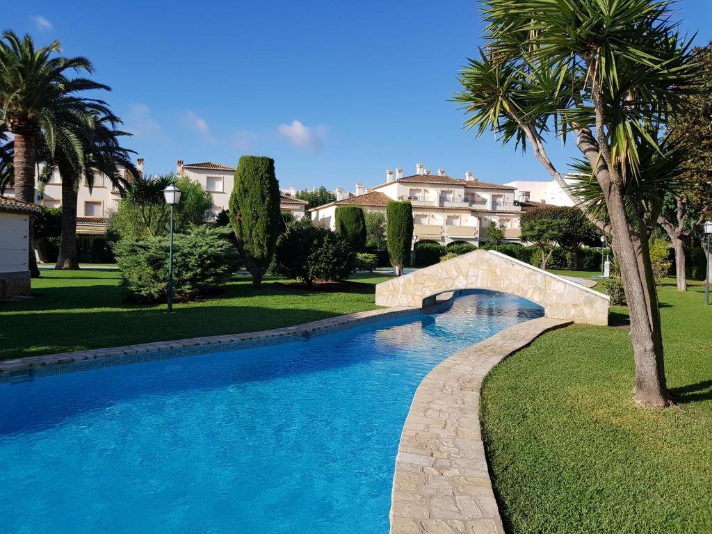 einen Pool mit einer Brücke und Palmen in der Unterkunft JAVEA - La Isla in Jávea