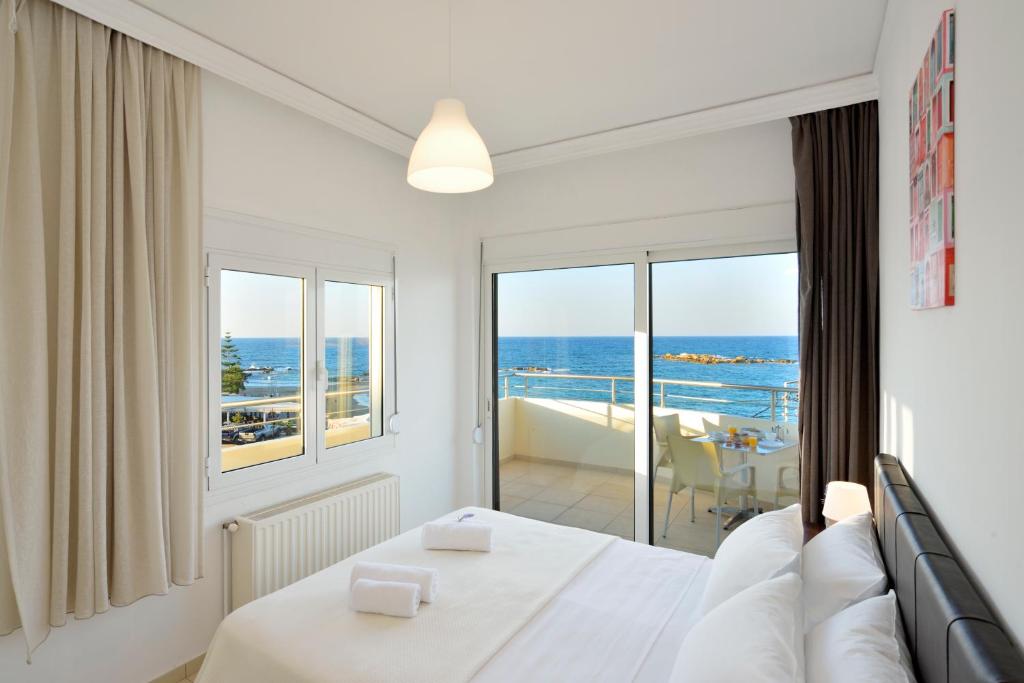 a bedroom with a bed and a view of the ocean at Kalamaki Apartments in Kalamaki Chanion