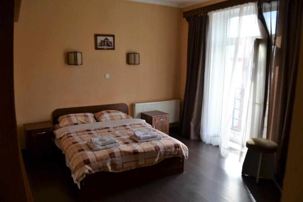 チェルニウツィーにあるKalinaのベッドルーム1室(ベッド1台、大きな窓付)