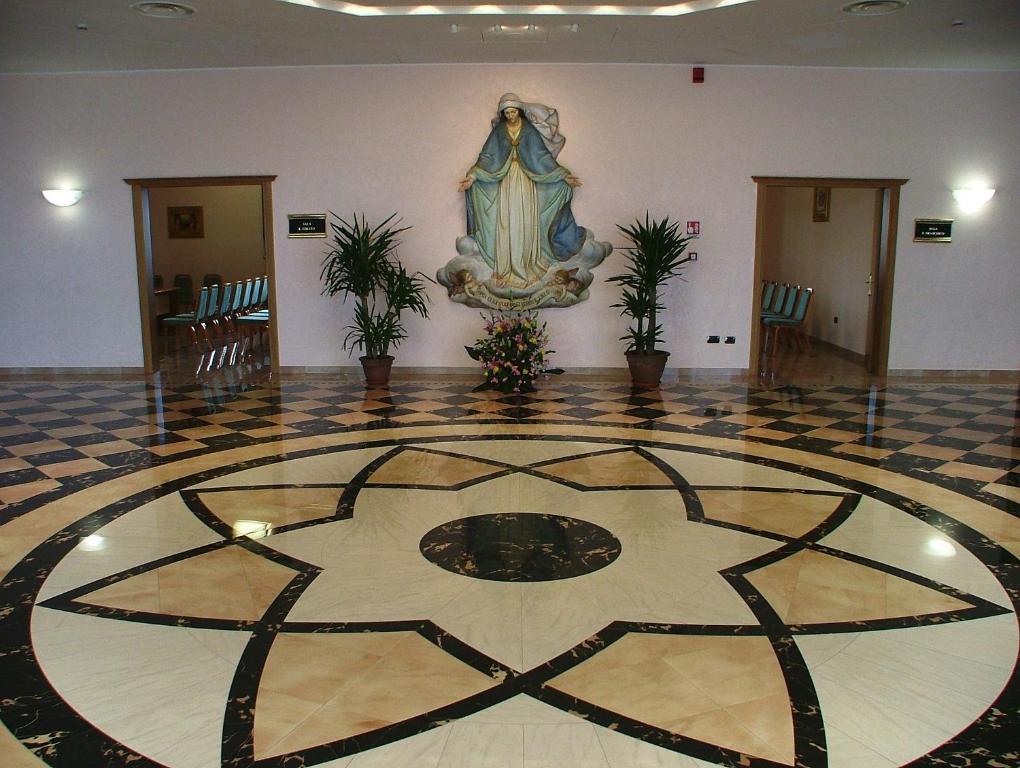 a lobby with a tiled floor with a picture on the wall at Hotel Centro di Spiritualità Padre Pio in San Giovanni Rotondo
