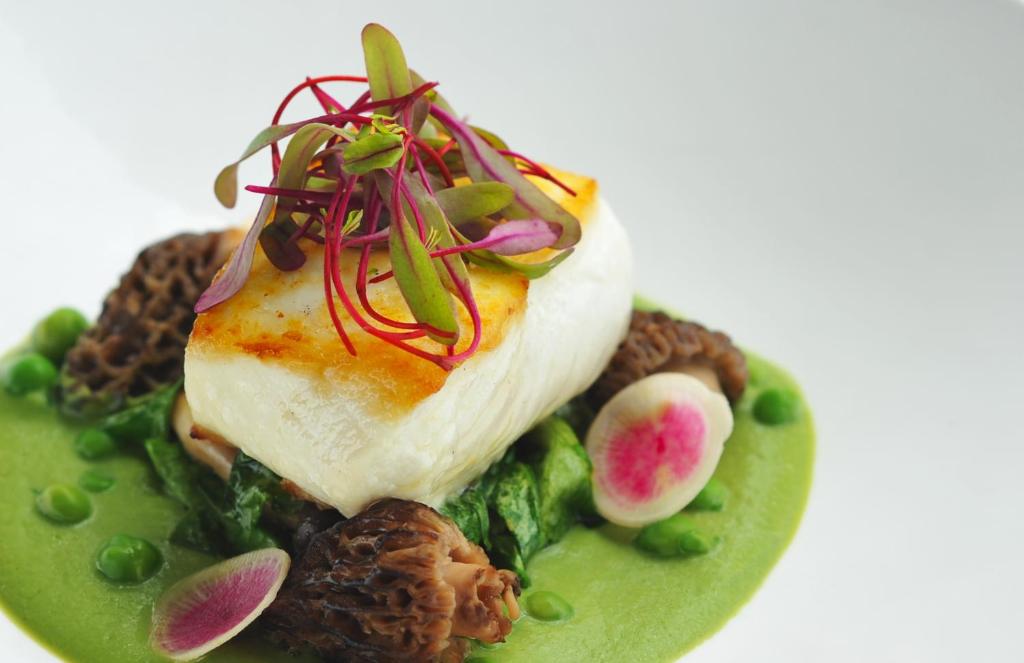 a piece of fish on a plate with peas and vegetables at Tower 23 Hotel in San Diego