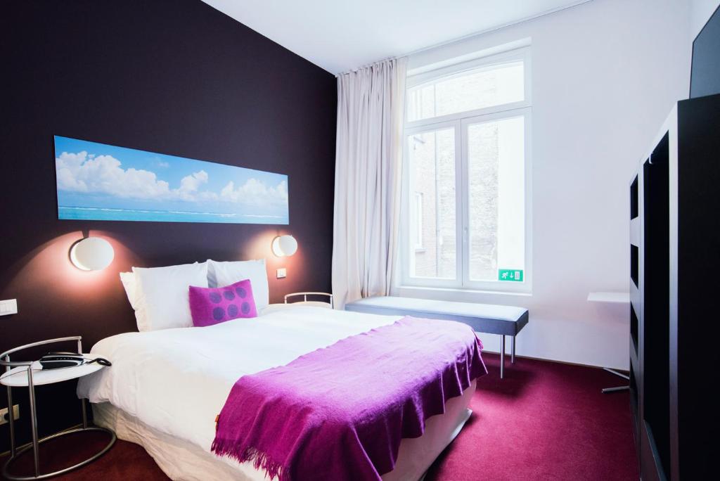 um quarto com uma cama grande e uma janela em Smartflats - Pacific Brussels em Bruxelas