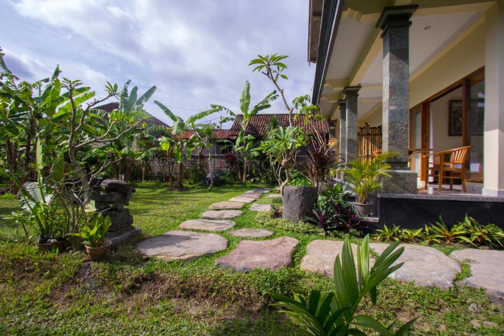 einen Garten mit Felsen und Pflanzen vor einem Haus in der Unterkunft Yudha Ubud in Ubud