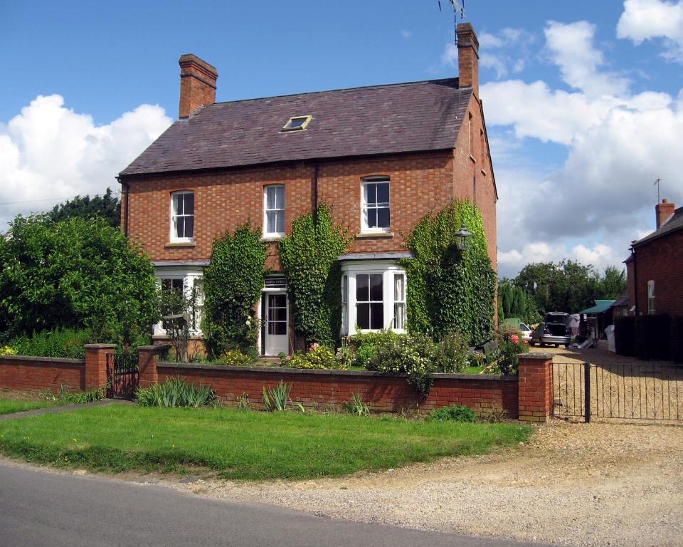 una casa de ladrillo con hiedra creciendo en ella en Winton House en Stratford-upon-Avon