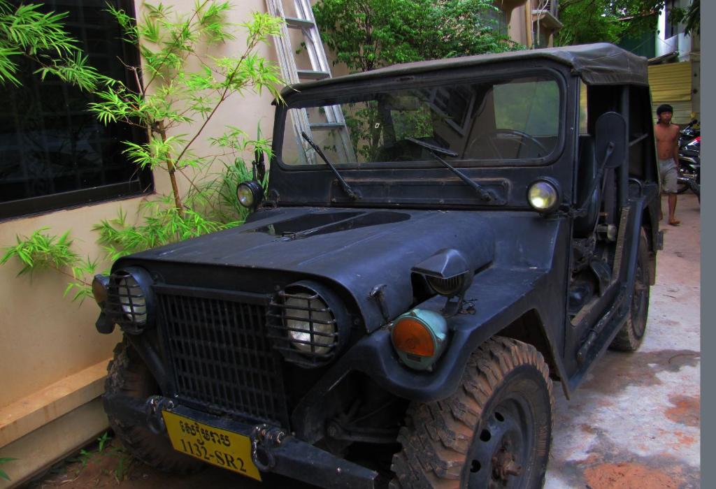 a black jeep parked next to a building at Blossoming Romduol Boutique in Siem Reap