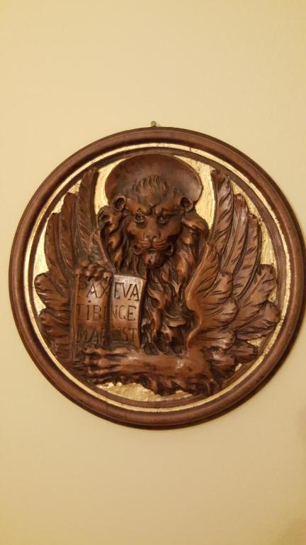 una placa de bronce de un león sosteniendo una casa en 3B Locazione Turistica, en Mestre