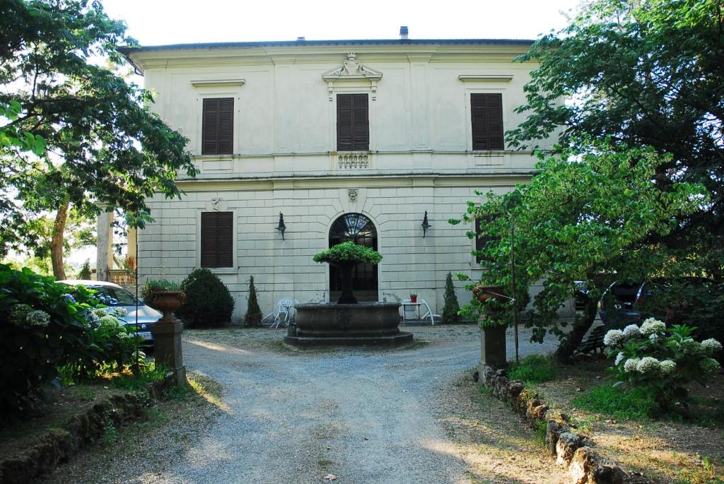 un gran edificio blanco con una fuente frente a él en B&B Villa Gualterio en Bolsena