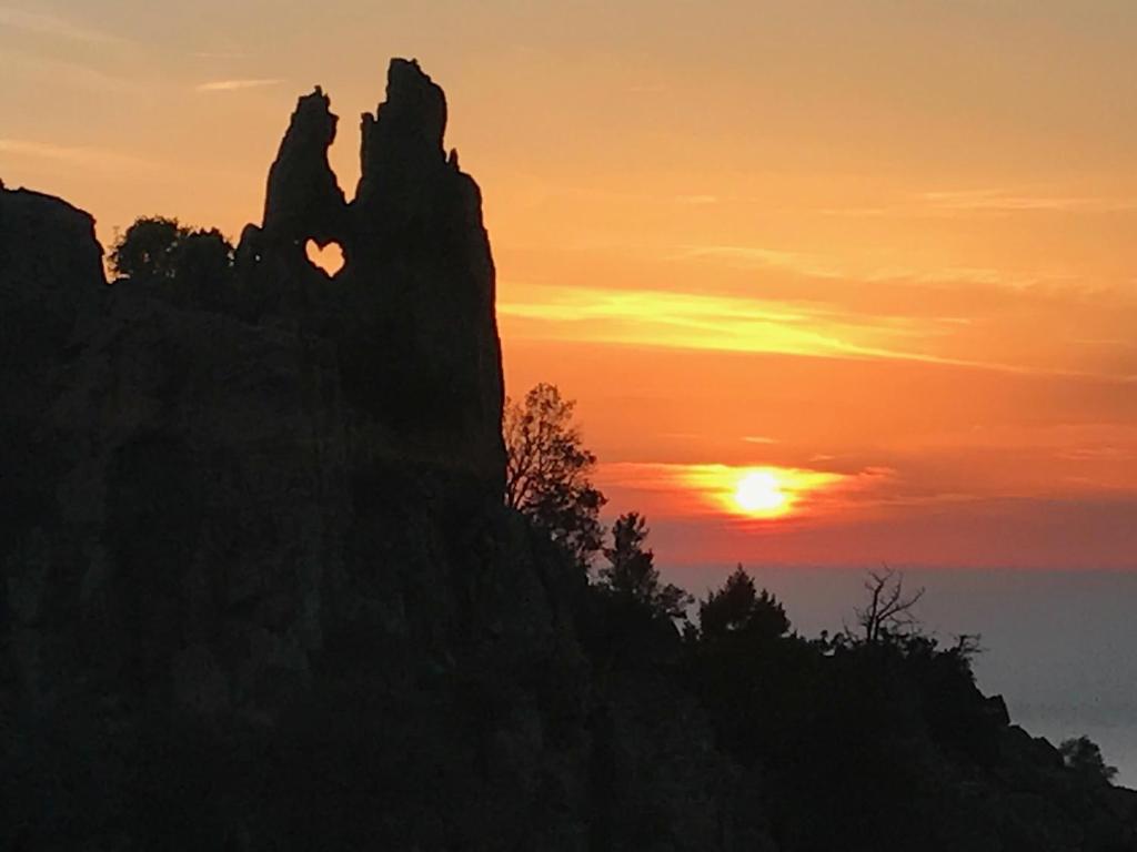 a silhouette of a mountain at sunset at A Stalla in Piana