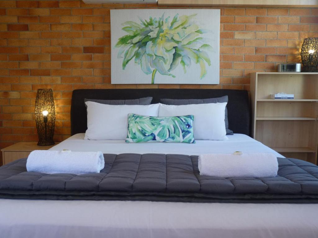 um quarto com uma cama grande e 2 almofadas em Sunseeker Motel em Hervey Bay