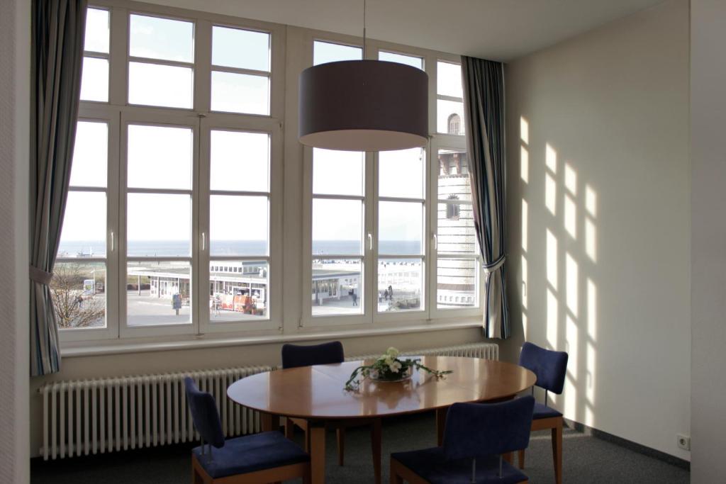 uma sala de jantar com uma mesa e uma grande janela em Apartmenthaus Am Leuchtturm em Warnemünde