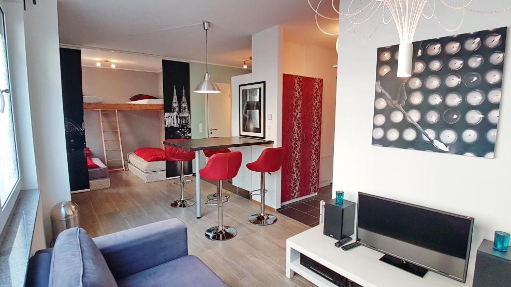 a living room with a blue couch and red chairs at Apartment Christian in Cologne