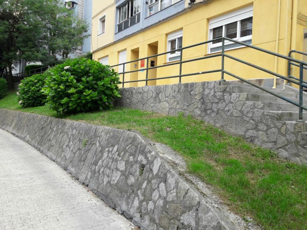 a stone retaining wall next to a building at A.T. Altamira 15 in Bilbao