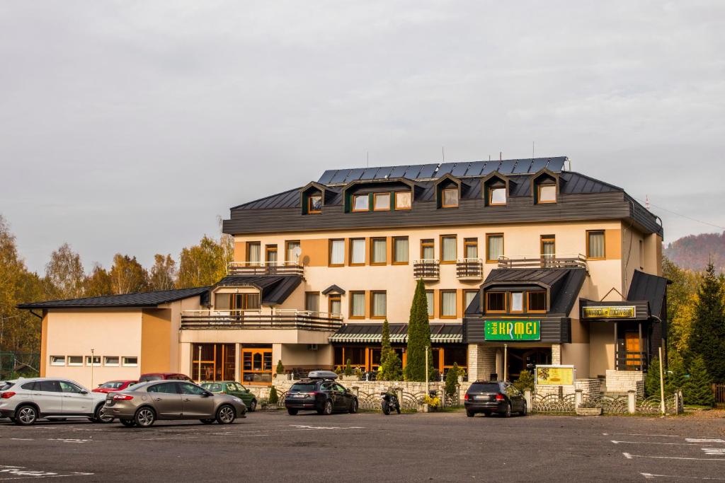 un gran edificio con coches estacionados en un estacionamiento en Hotel Kamei, en Snina