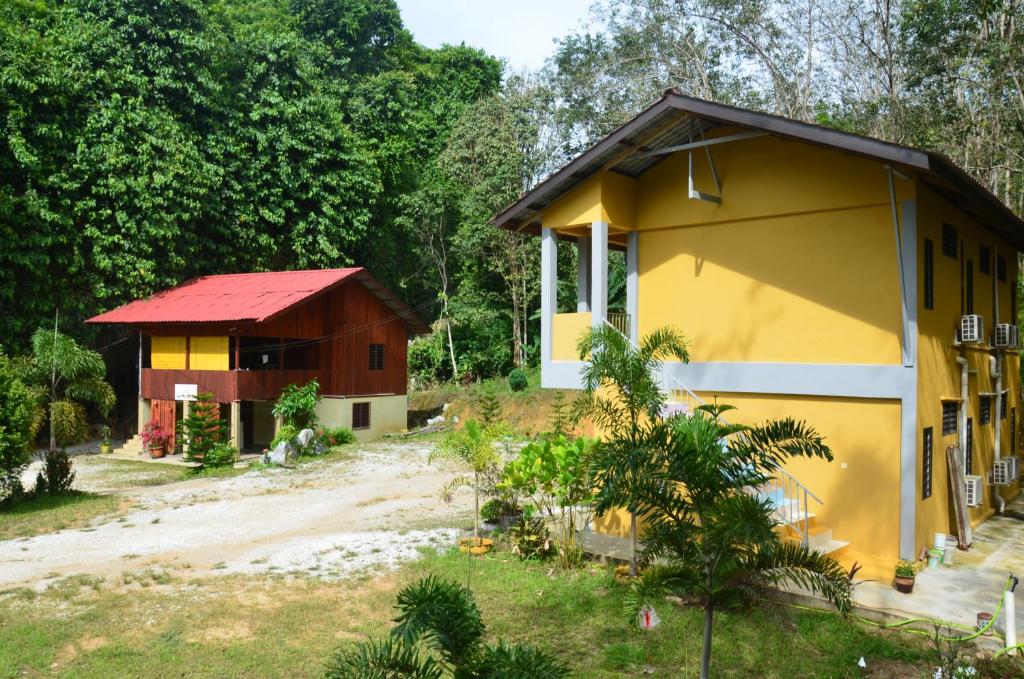 
a small house with trees and a building at Country house Pulai Holiday Village in Gua Musang
