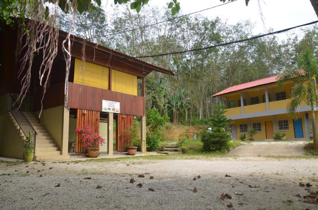 uma casa com um edifício amarelo e azul em Country house Pulai Holiday Village em Gua Musang