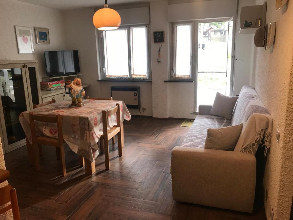uma sala de estar com uma mesa e um sofá em Appartamento Saint Gréé em Viola