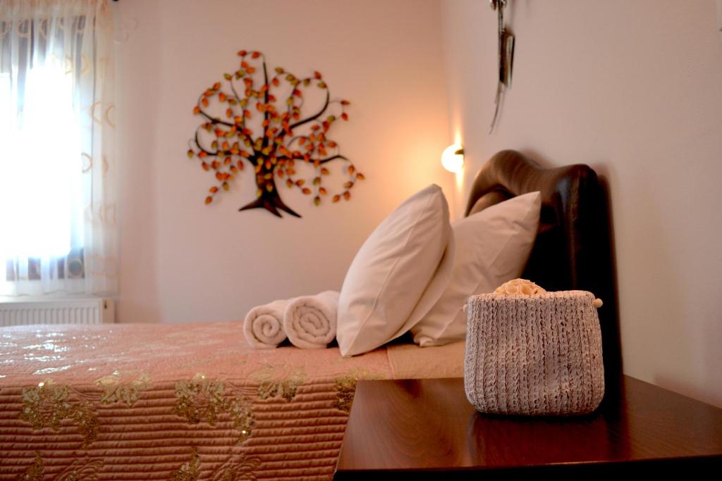 Habitación con cama con almohadas y árbol en la pared. en Anesis en Ioánina