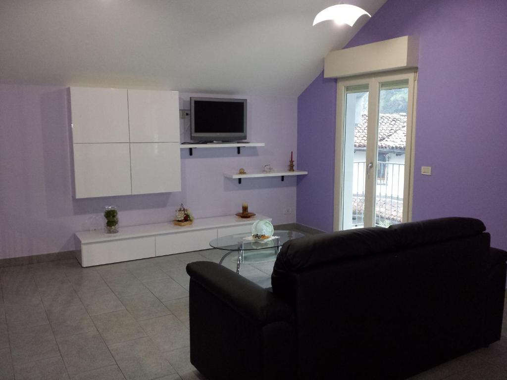 カンノビオにあるAppartamento Due Vialiの紫の壁のリビングルーム(黒いソファ付)