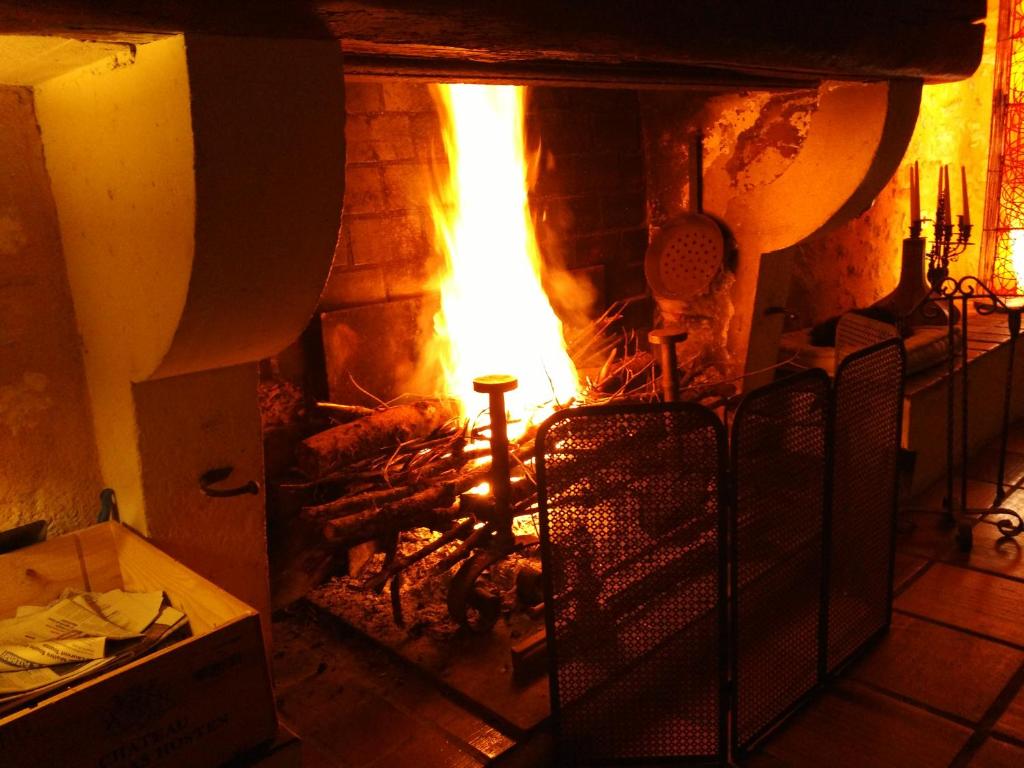 a brick fireplace with a fire in it at Chambre d&#39;hôtes Le Moulin de Moulis in Moulis-en-Médoc
