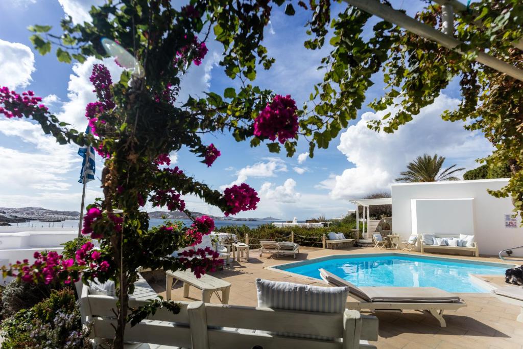 a villa with a swimming pool and flowers at Rhenia Hotel in Tourlos