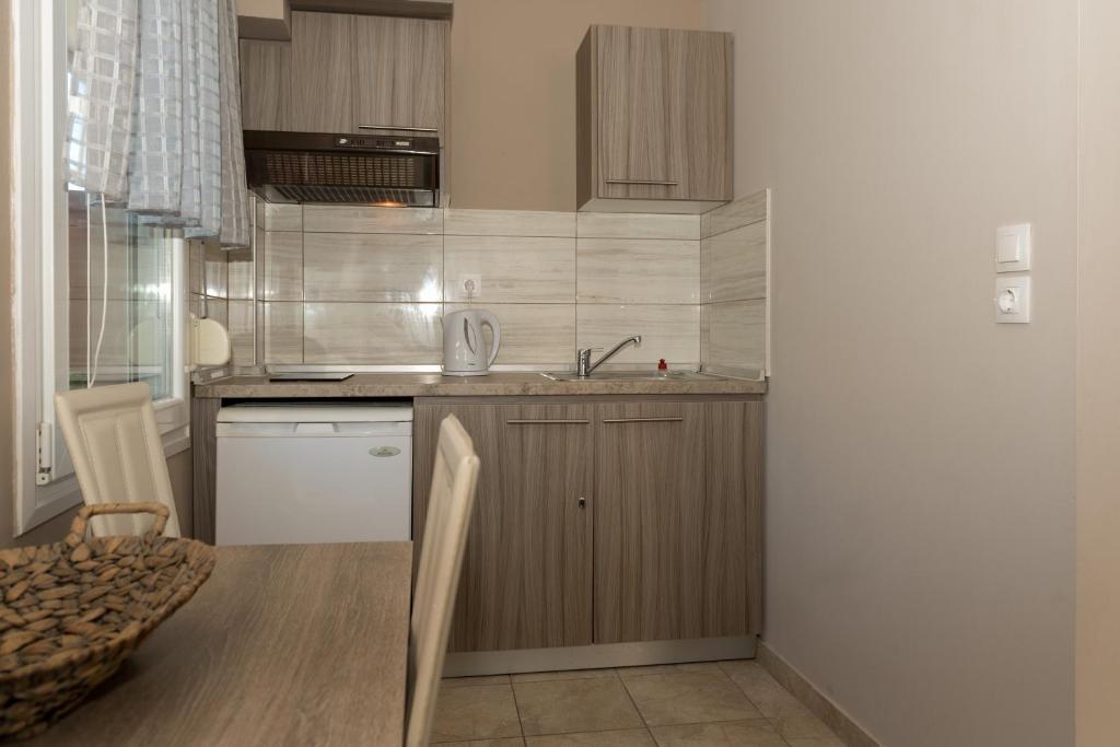 a small kitchen with a table and a sink at Tzamtzis Apartments in Keramoti