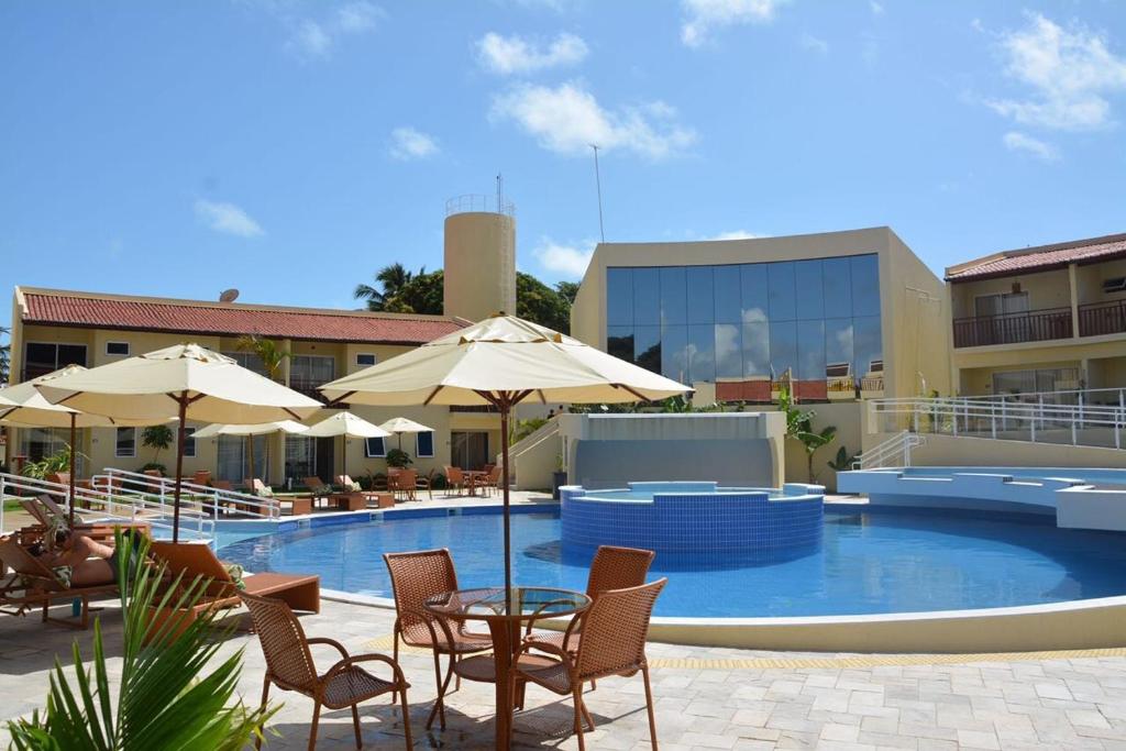 - une piscine avec des chaises, des tables et des parasols dans l'établissement Solar Água Pipa, à Pipa