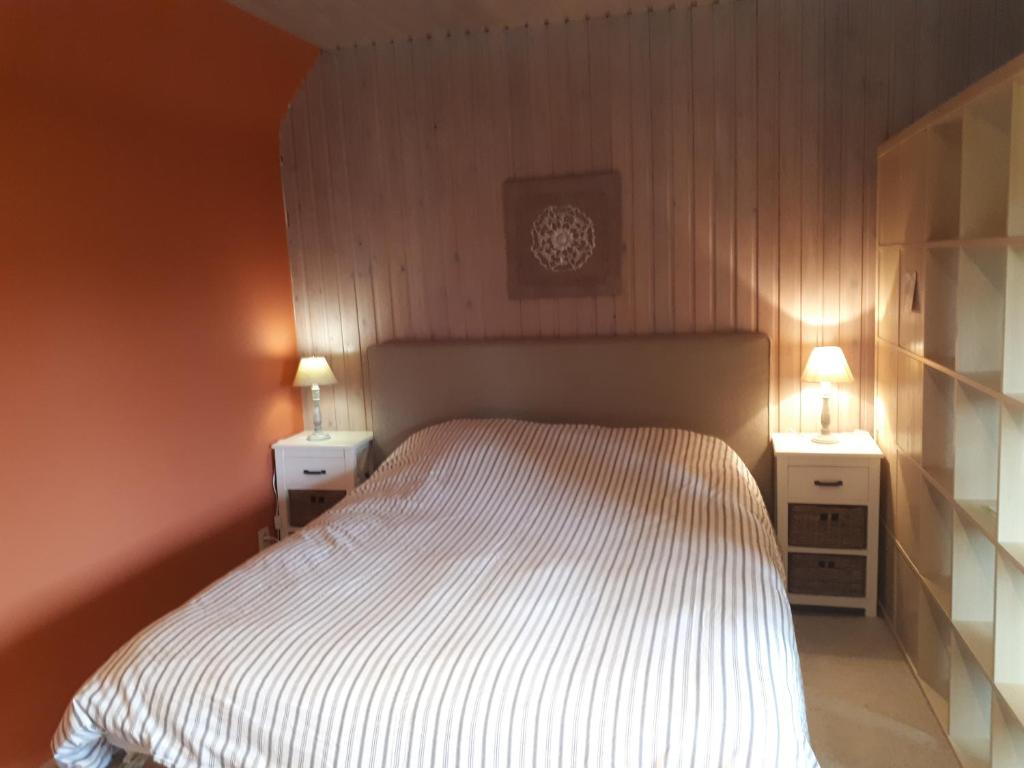 a bedroom with a bed with two night stands and a clock at Escale de Brionsart in Gesves