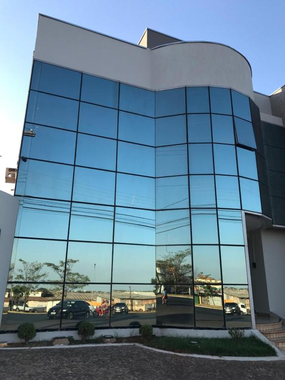 un bâtiment en verre avec vue sur un parking dans l'établissement Oásis Hotel, à Araguaína