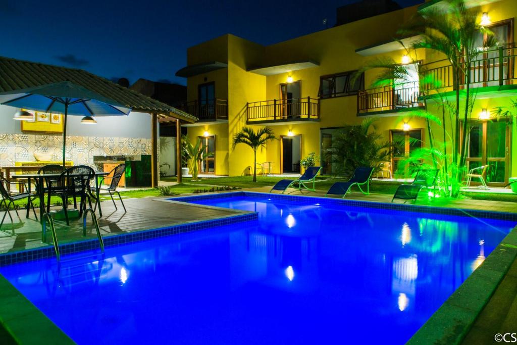 a villa with a swimming pool at night at Atlantica Apartamentos Imbassai in Imbassai