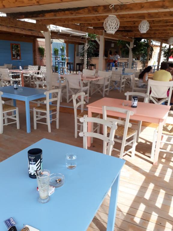 restauracja z niebieskimi stołami i białymi krzesłami w obiekcie Apartment Alexis Armeno w mieście Marathias