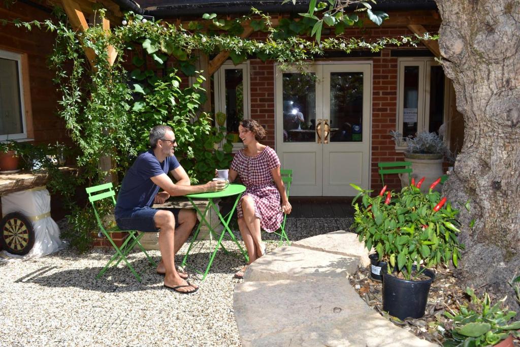 a man and woman sitting at a table in a backyard at The Kingsley at Eversley in Eversley