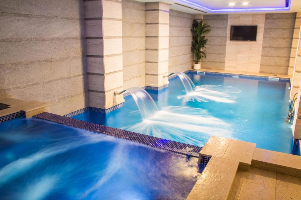a pool in a hotel with two water slides at Xenon Hotel & SPA in Belgrade