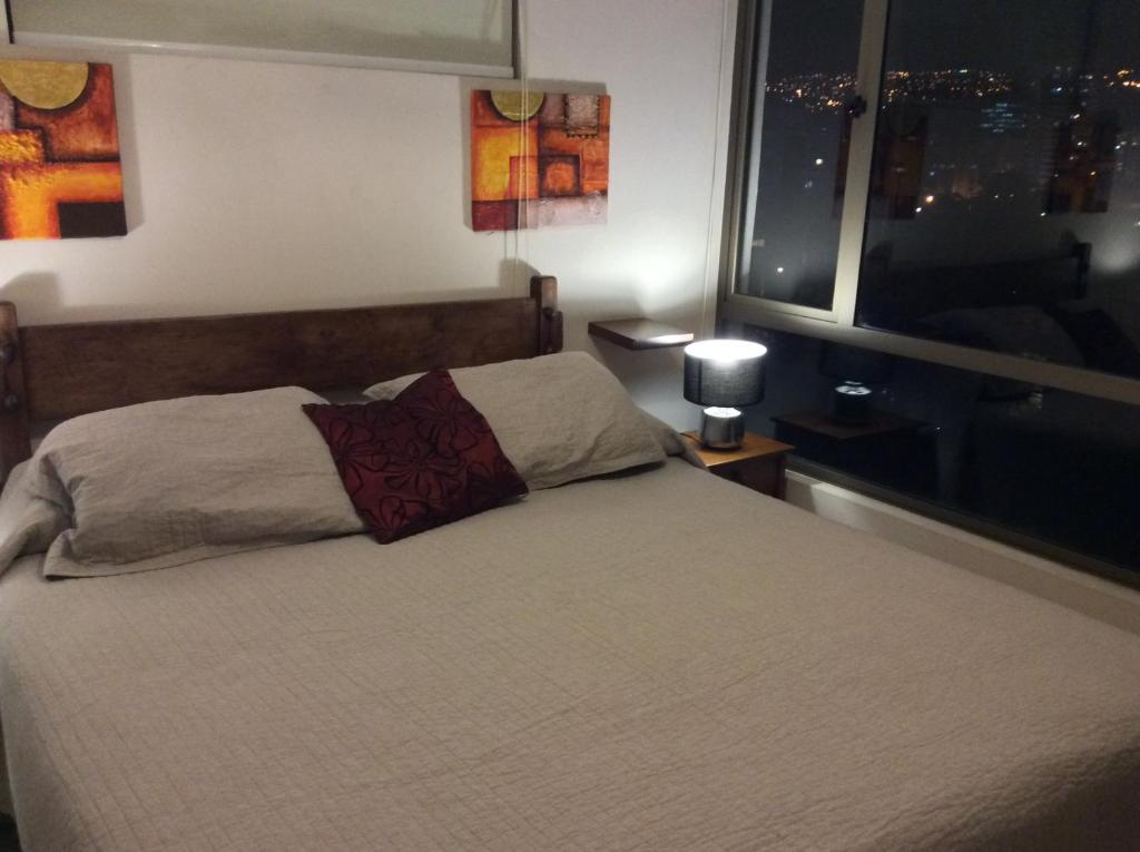 1 dormitorio con 1 cama grande y ventana en Departamento 3 Norte, en Viña del Mar