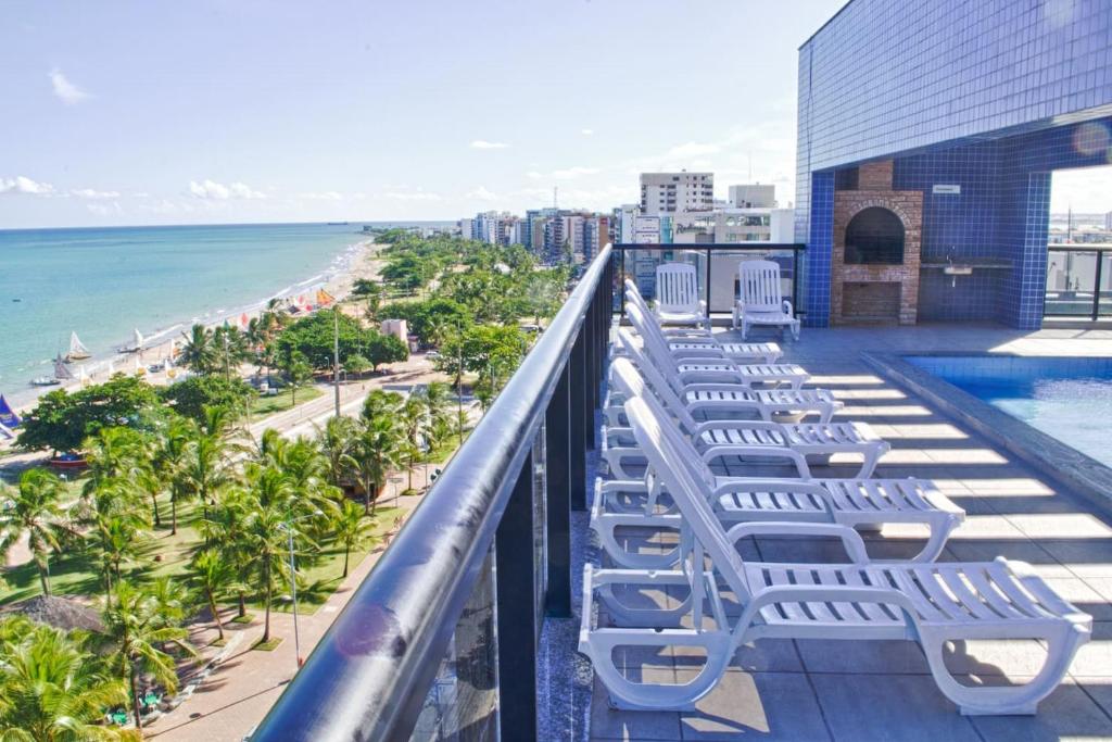 balcón con tumbonas y vistas a la playa en NEO 2 Beira Mar Praia Pajuçara en Maceió
