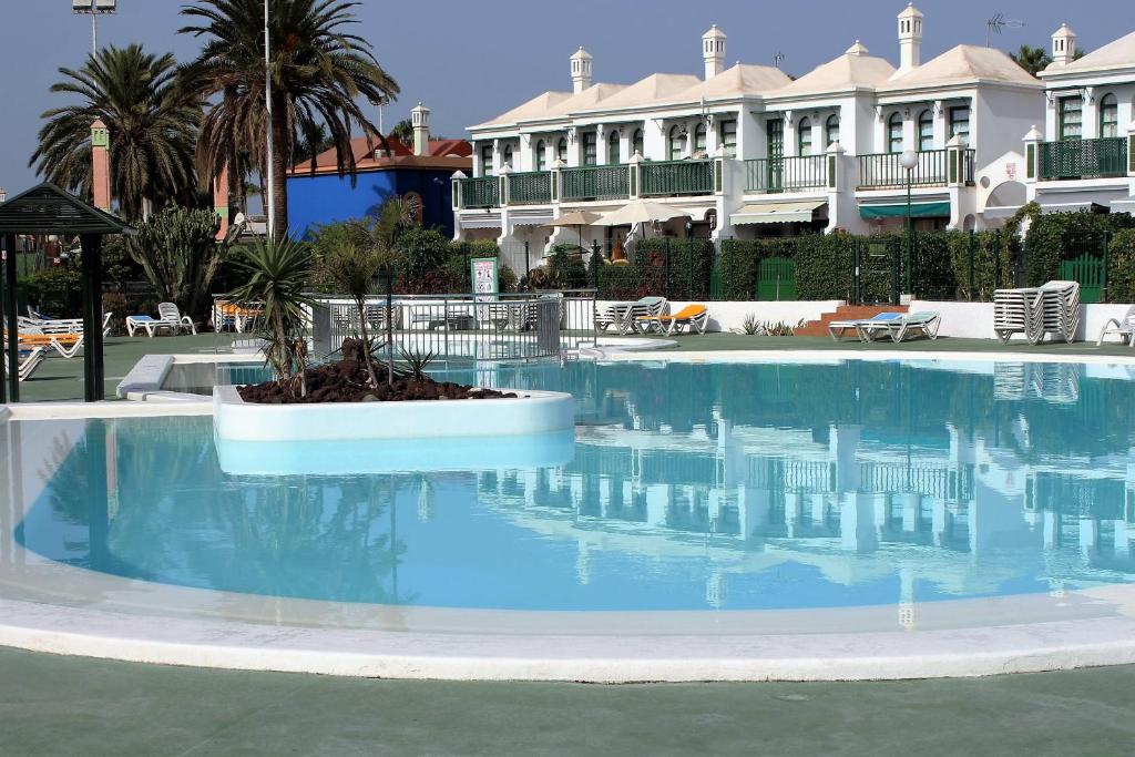 een groot zwembad met blauw water in een resort bij Bungalow Duna Flor Verde in Maspalomas