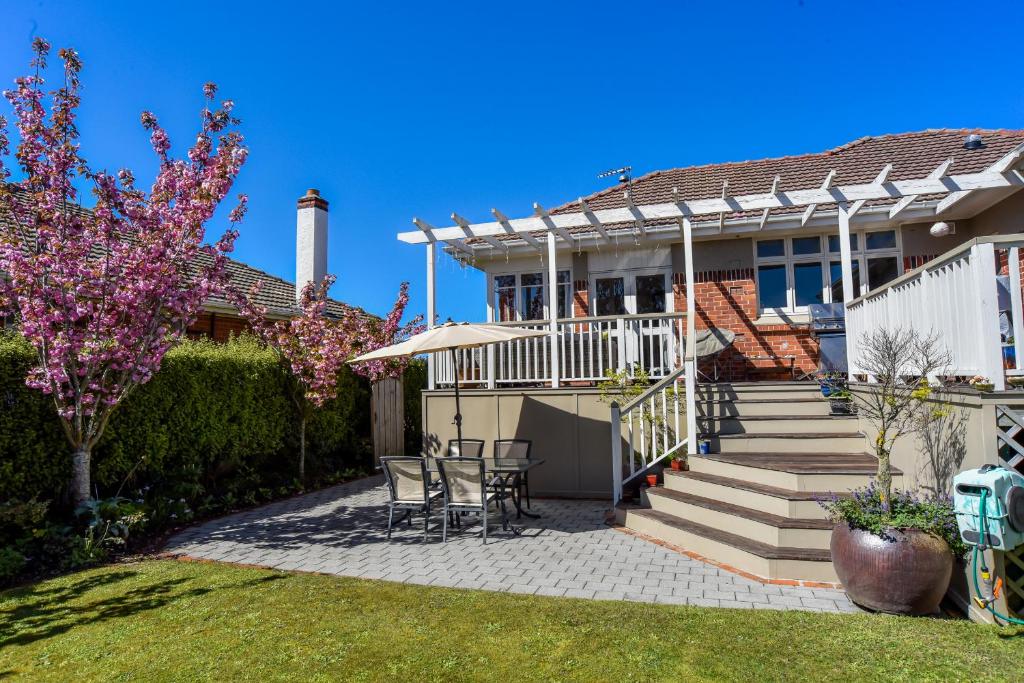 una casa con patio arredato con tavolo e sedie di Sunny Mornington 2 Bedroom Guest Suite a Dunedin