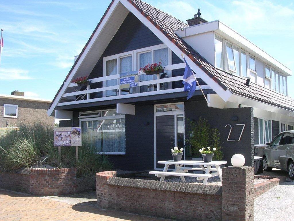 una casa negra con una mesa delante en Appartementen Bergen aan Zee de Schelp, en Bergen aan Zee