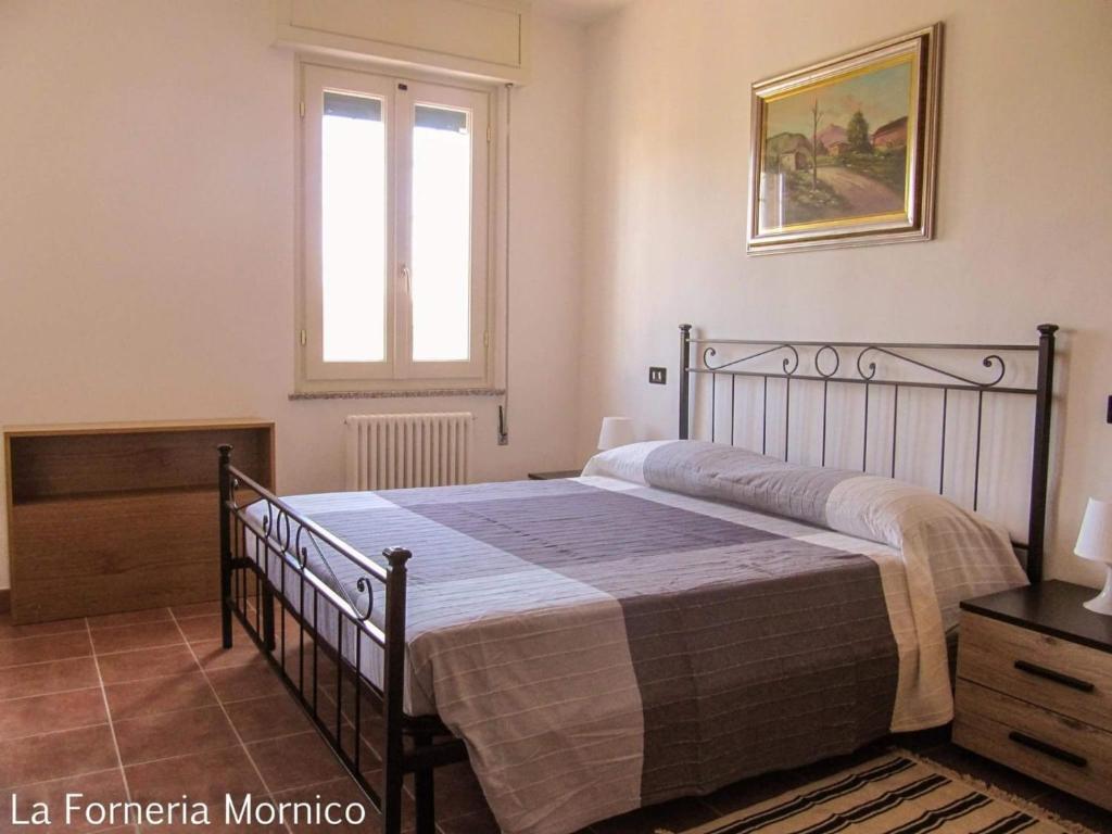 1 dormitorio con cama y ventana en laforneriamornico, en Mornico Losana
