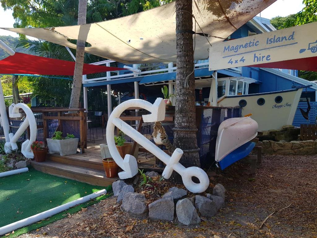 une statue d'un banc assise devant une maison dans l'établissement Arcadia Beach Guest House and Car Hire, à Nelly Bay