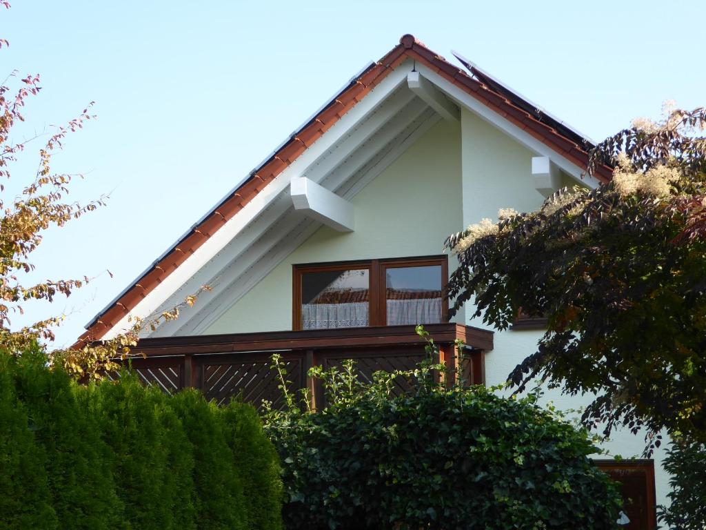 ノイエンビュルクにあるEnzkreisspitzeの赤い屋根と木々のある白い家