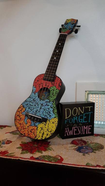 a guitar is sitting next to a dont forget anymore sign at Crossroads Hostel Manila in Manila