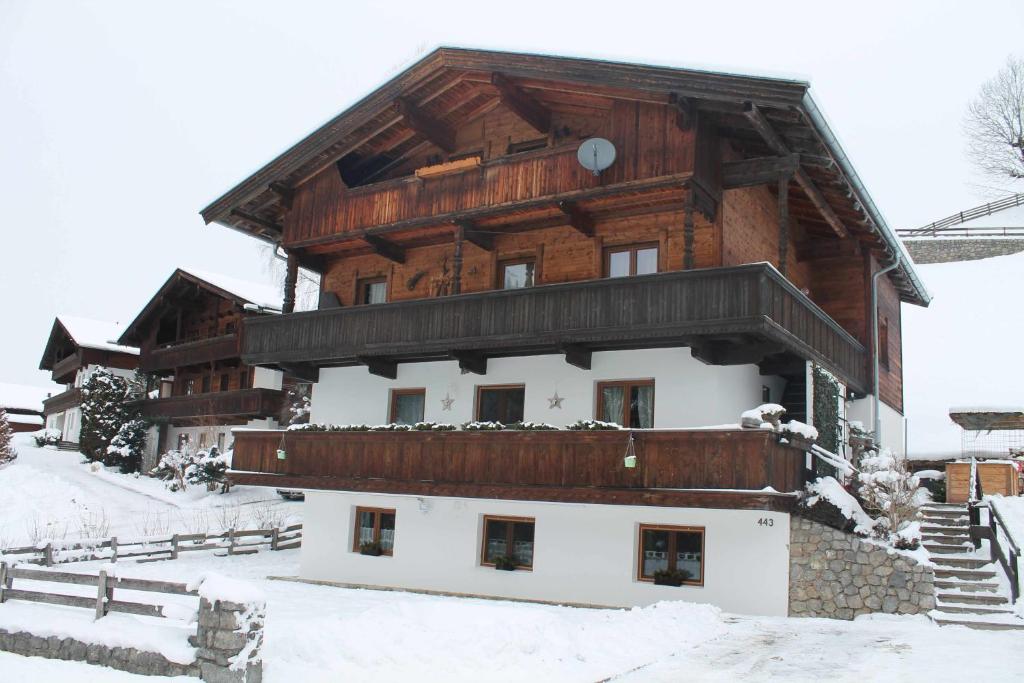 a large building with a wooden roof in the snow at Apartment Sagtaler Spitze in Alpbach