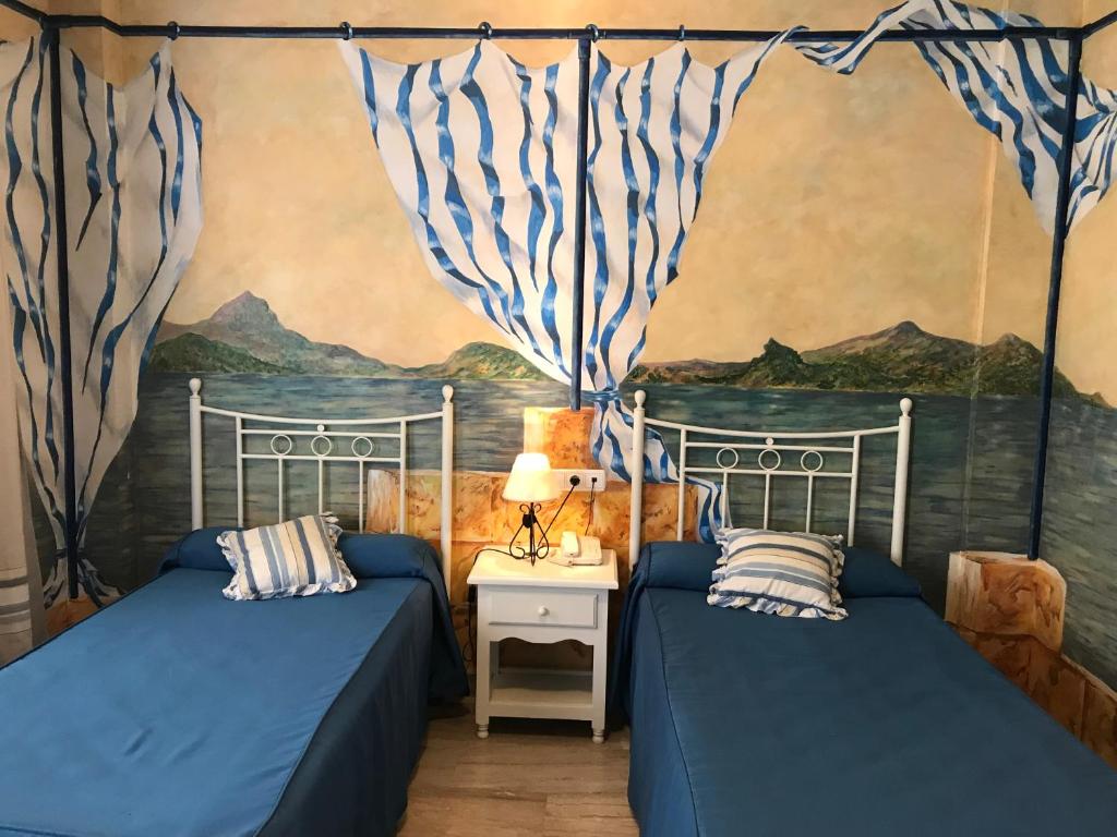 sypialnia z 2 łóżkami i obrazem na ścianie w obiekcie Hotel Las Rosas w mieście Priego de Córdoba
