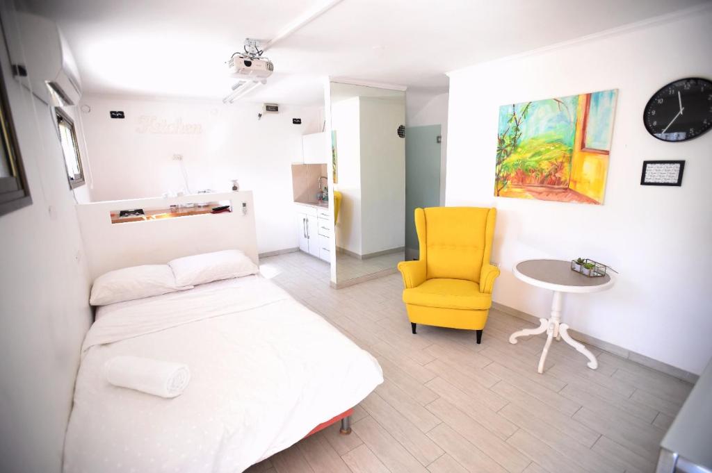 a bedroom with a bed and a yellow chair at Blue Sky in Ashkelon in Ashkelon