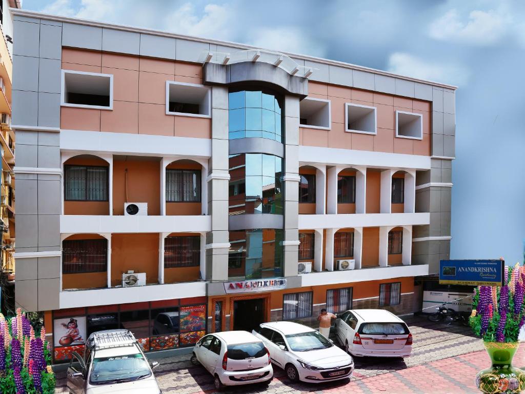 a building with cars parked in front of it at Anandkrishna Residency in Guruvāyūr