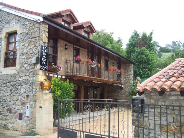 a building with a balcony with flowers on it at Posada El Pescador in Oreña