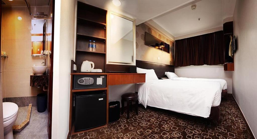 a hotel room with a bed and a bathroom at Lander Hotel Prince Edward in Hong Kong