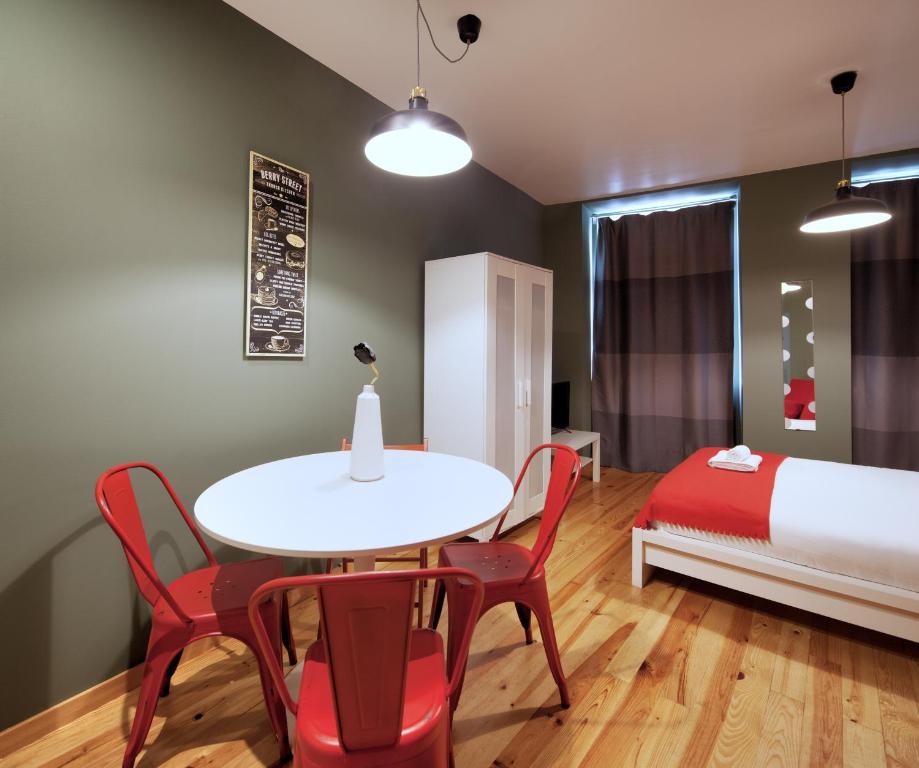 a room with a table and chairs and a bed at Aparthotel Oporto Entreparedes in Porto