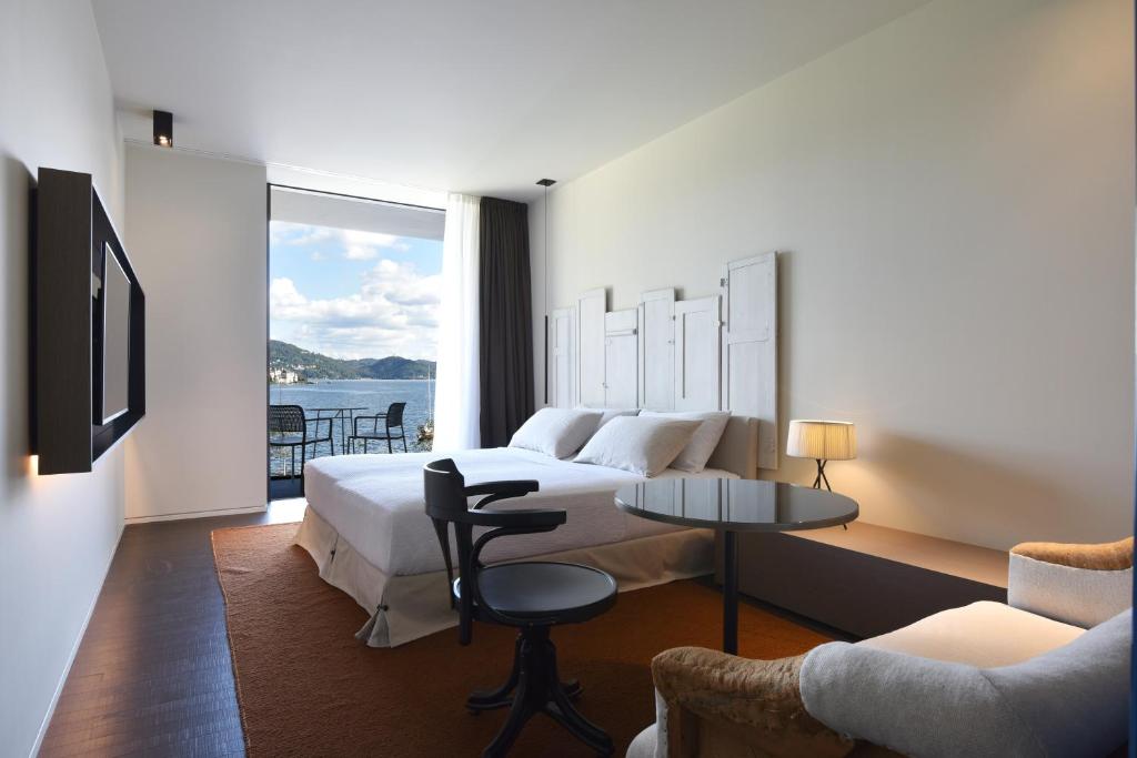 Cette chambre d'hôtel comprend un lit et offre une vue sur l'eau. dans l'établissement Casa Fantini - Lake Time, à Pella